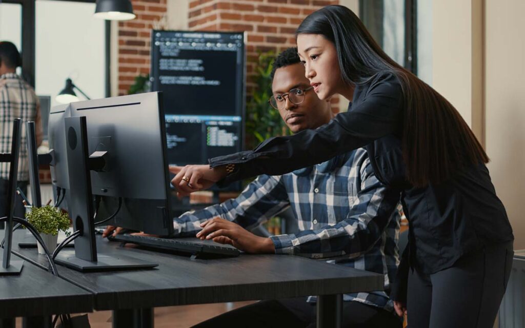 employee showing another employee something on computer