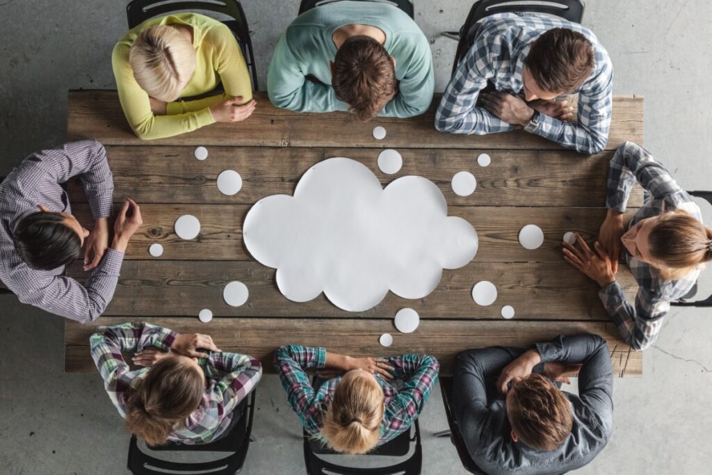 employees sharing a thought bubble around a table