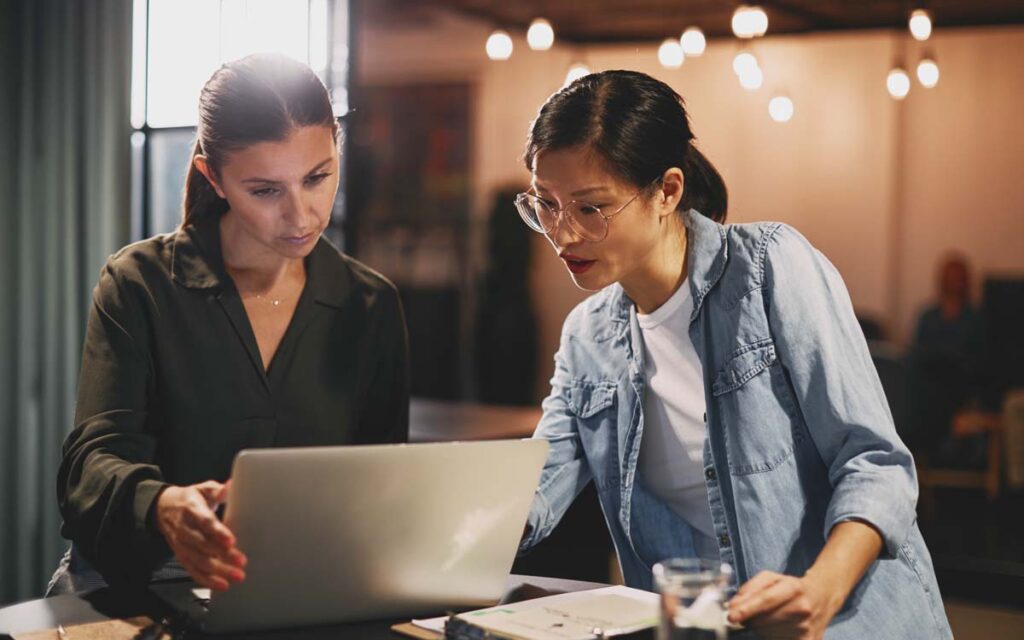 two employees examining a computer screen